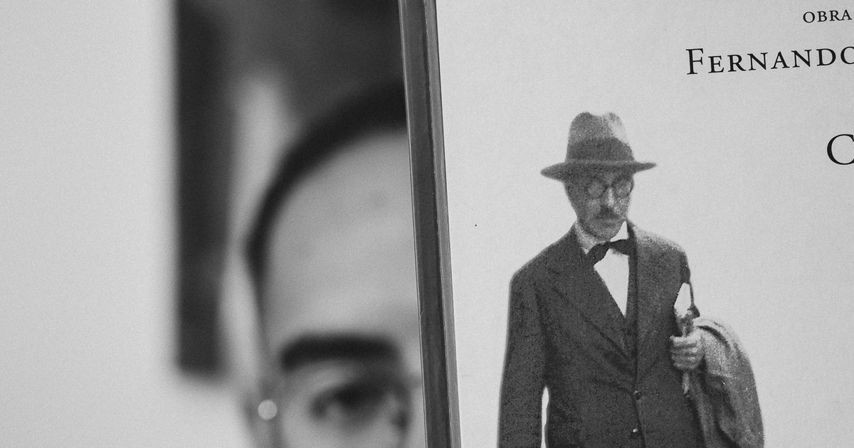 Livro de Fernando Pessoa diante do rosto do Dr. Ariosto Ribeiro, em preto e branco