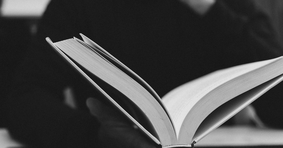 Livro aberto nas mãos do Dr. Ariosto Ribeiro